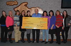Laura L., fourth from the right, accepts her $10,000 check for winning Save to Win.